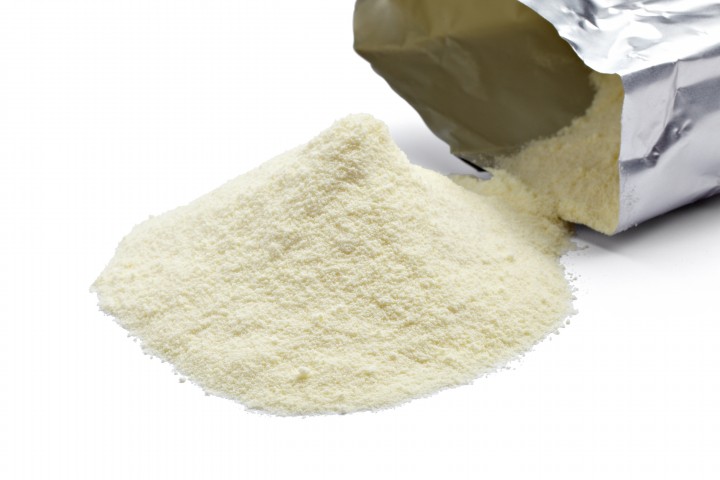 close up of powdered milk and spoon for baby on white background with clipping path