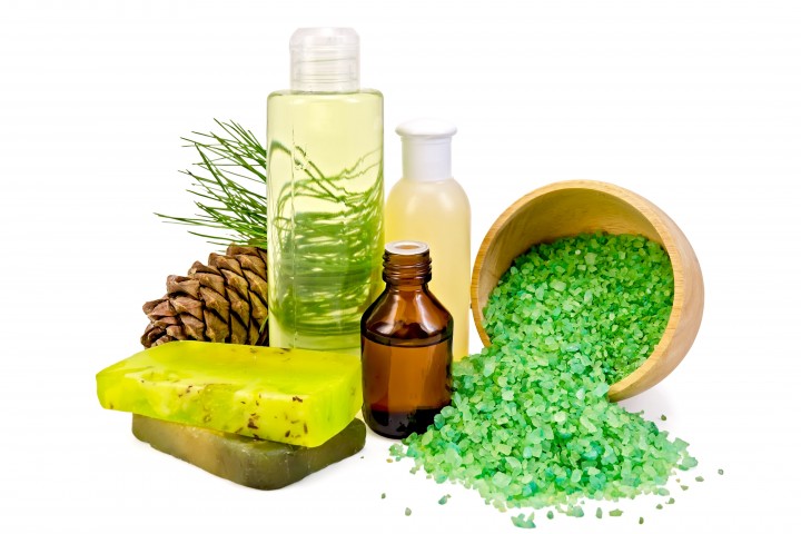 cedar oil in a bottle pine cones with branch two green homemade soap salt in a wooden bow